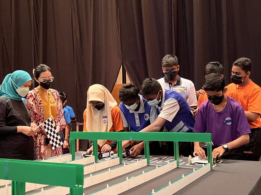 Shariah Nelly Francis, CEO of Yayasan PETRONAS witnessing the Elasticity, Potential, and Kinetics (ELPOKI) Car final heat race.